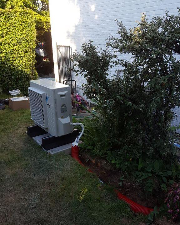 Pompe à chaleur air/eau installée dans le jardin d'une maison unifamiliale