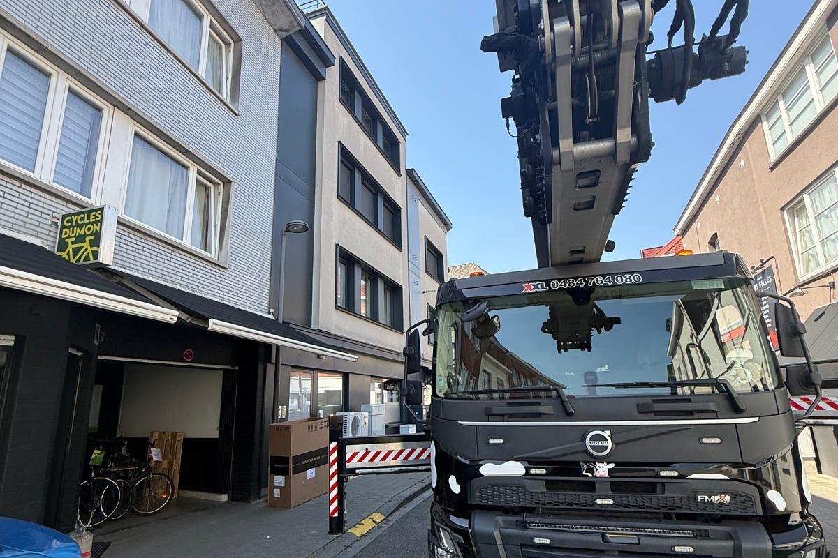 Camion avec grue de manutention en intervention devant un commerce