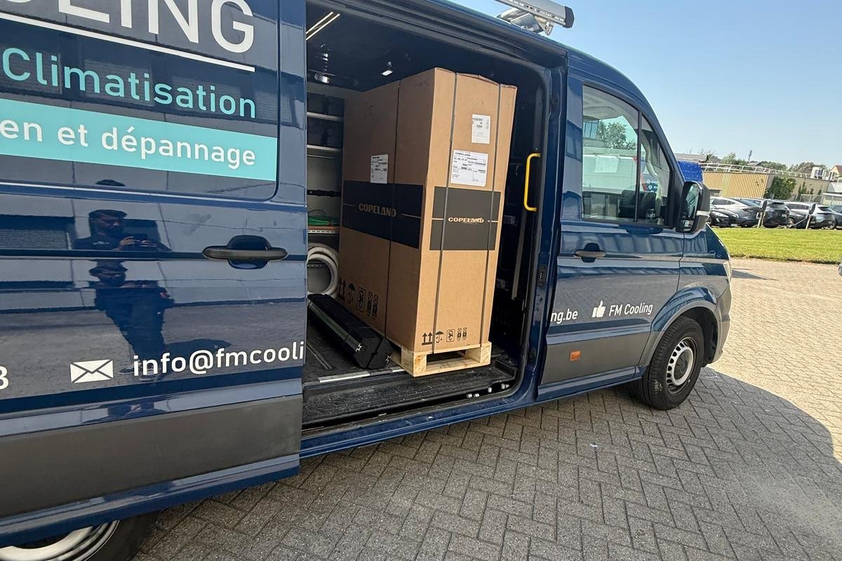 Camionnette FM Cooling chargée de matériel devant un chantier